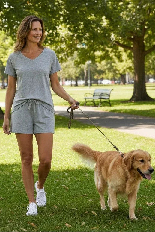 Woman walking a golden retriever dog in a park