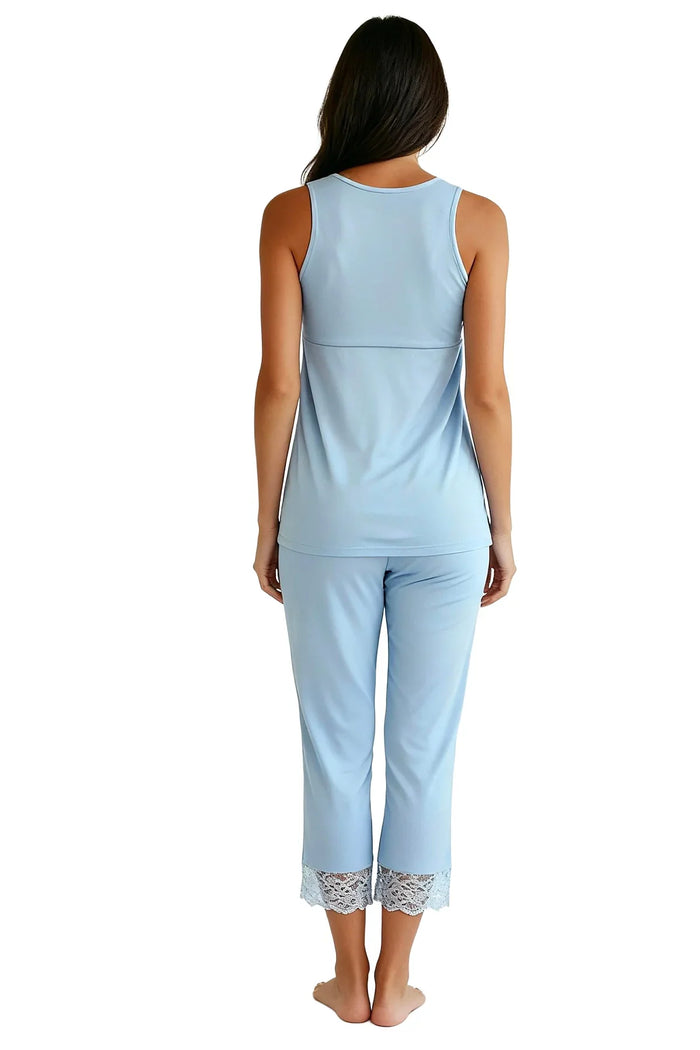 Woman wearing light blue sleeveless loungewear set with lace trim pants, back view