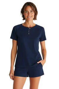 Woman wearing navy blue short sleeve pajama top and lounge shorts, white background