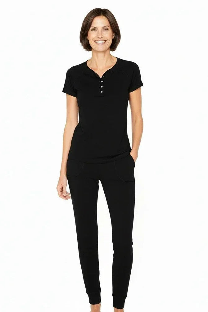 Woman wearing black short sleeve henley top and matching lounge pants, relaxed fit