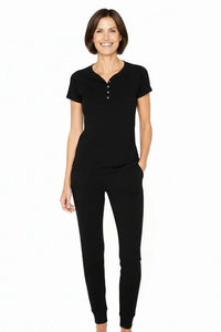 Woman wearing black short sleeve henley top and matching lounge pants, relaxed fit