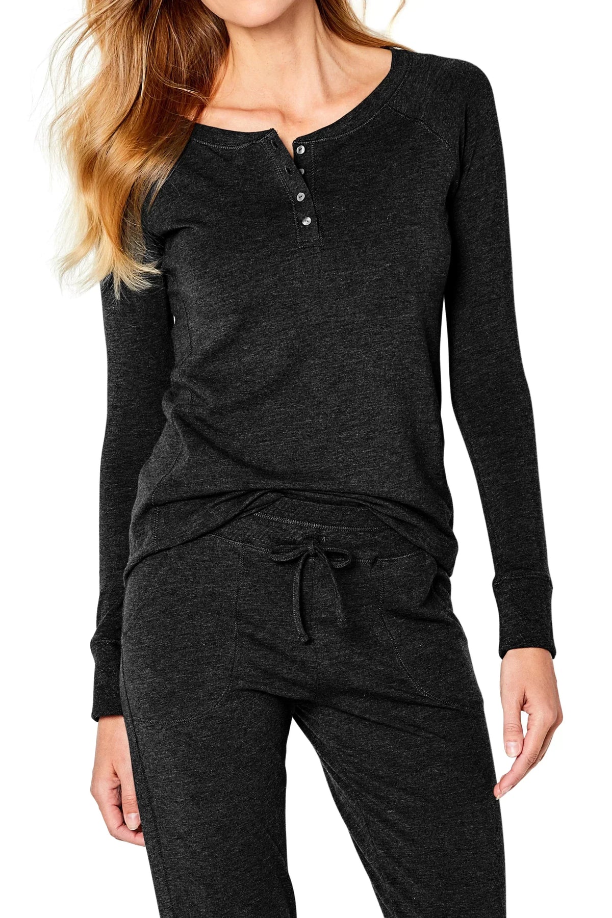 Woman wearing black long sleeve henley loungewear set with drawstring pants