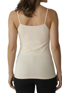 Back view of woman wearing almond color fitted spaghetti strap camisole and black pants