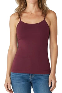 Woman wearing a fitted Bordeaux burgundy spaghetti strap tank top with blue jeans