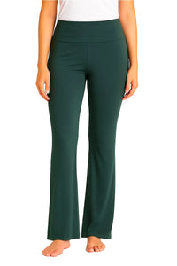 Woman wearing high-waisted spruce green flare yoga pants barefoot on white background
