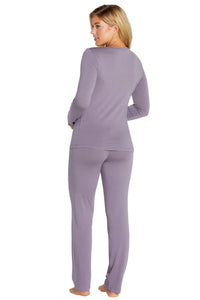 Woman wearing lavender long-sleeve top and matching pants loungewear, standing barefoot