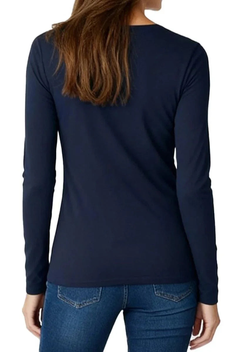 Woman wearing a midnight blue long sleeve shirt and blue jeans, viewed from the back