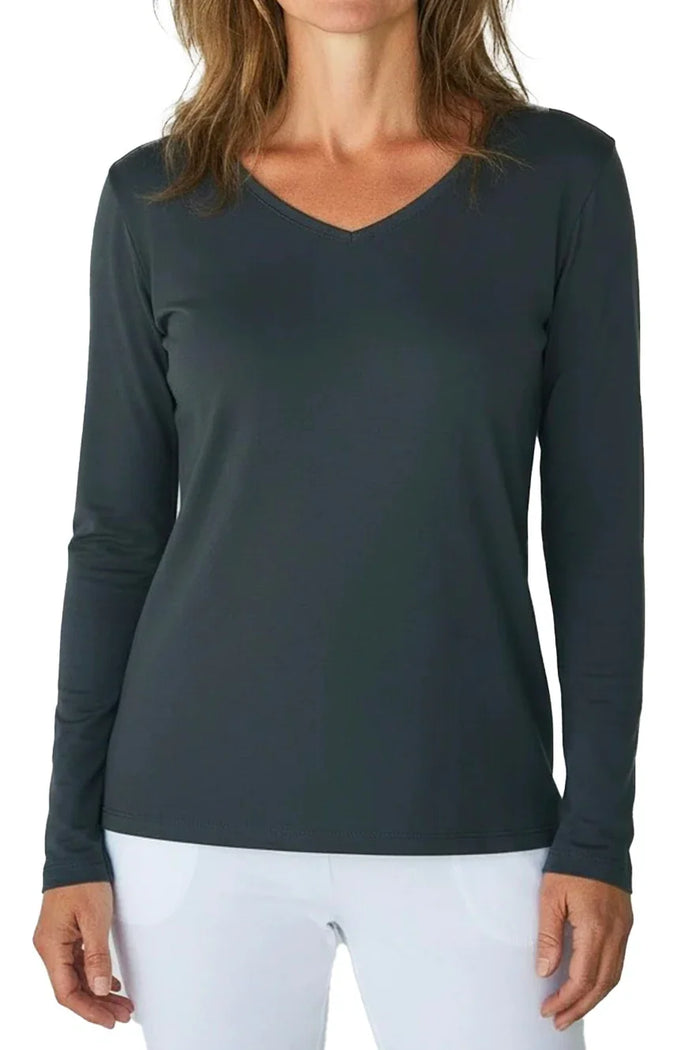 Woman wearing steel blue long-sleeve V-neck shirt and white pants against white background