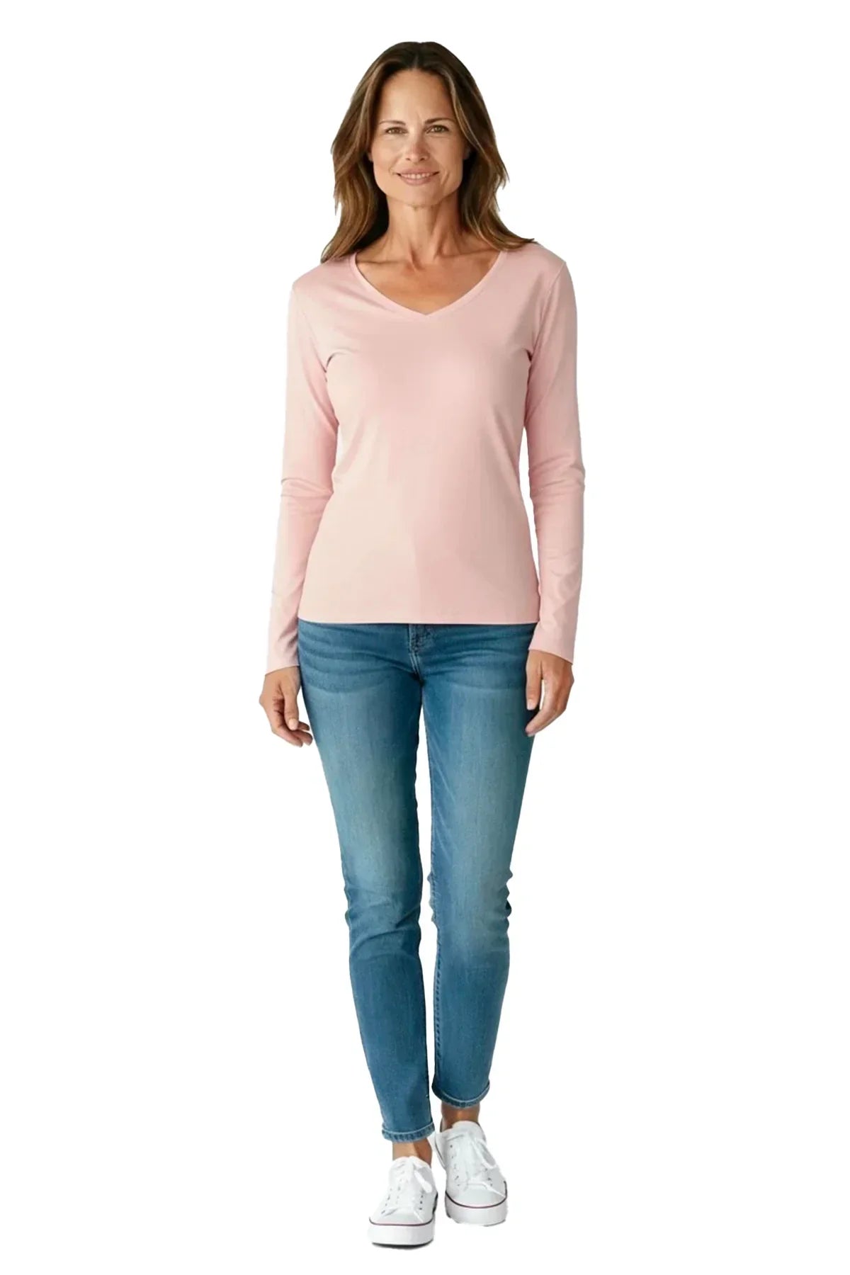 Woman wearing shell pink long-sleeve V-neck shirt, blue jeans, and white sneakers on white background