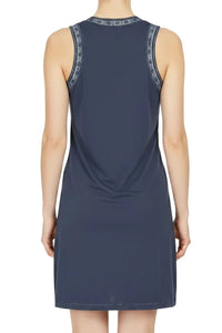 Back view of woman wearing a steel blue sleeveless dress with patterned trim on armholes and neckline