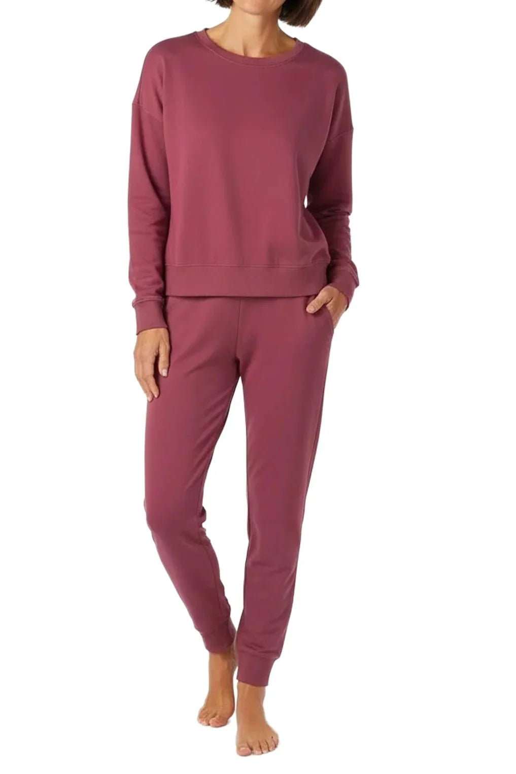 woman wearing rosewood-colored long sleeve sweatshirt and matching jogger pants, barefoot, studio background