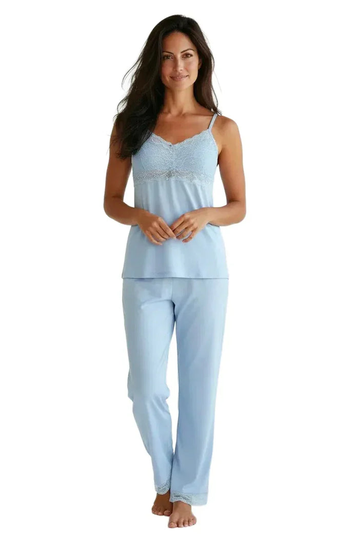 Woman wearing light blue spaghetti strap camisole pajama set with lace trim