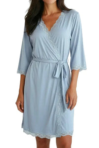 Woman wearing light blue chambray wrap dress with lace trim and three-quarter sleeves