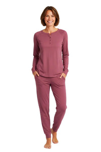 Woman wearing rosewood color long sleeve henley top and jogger pants loungewear set barefoot