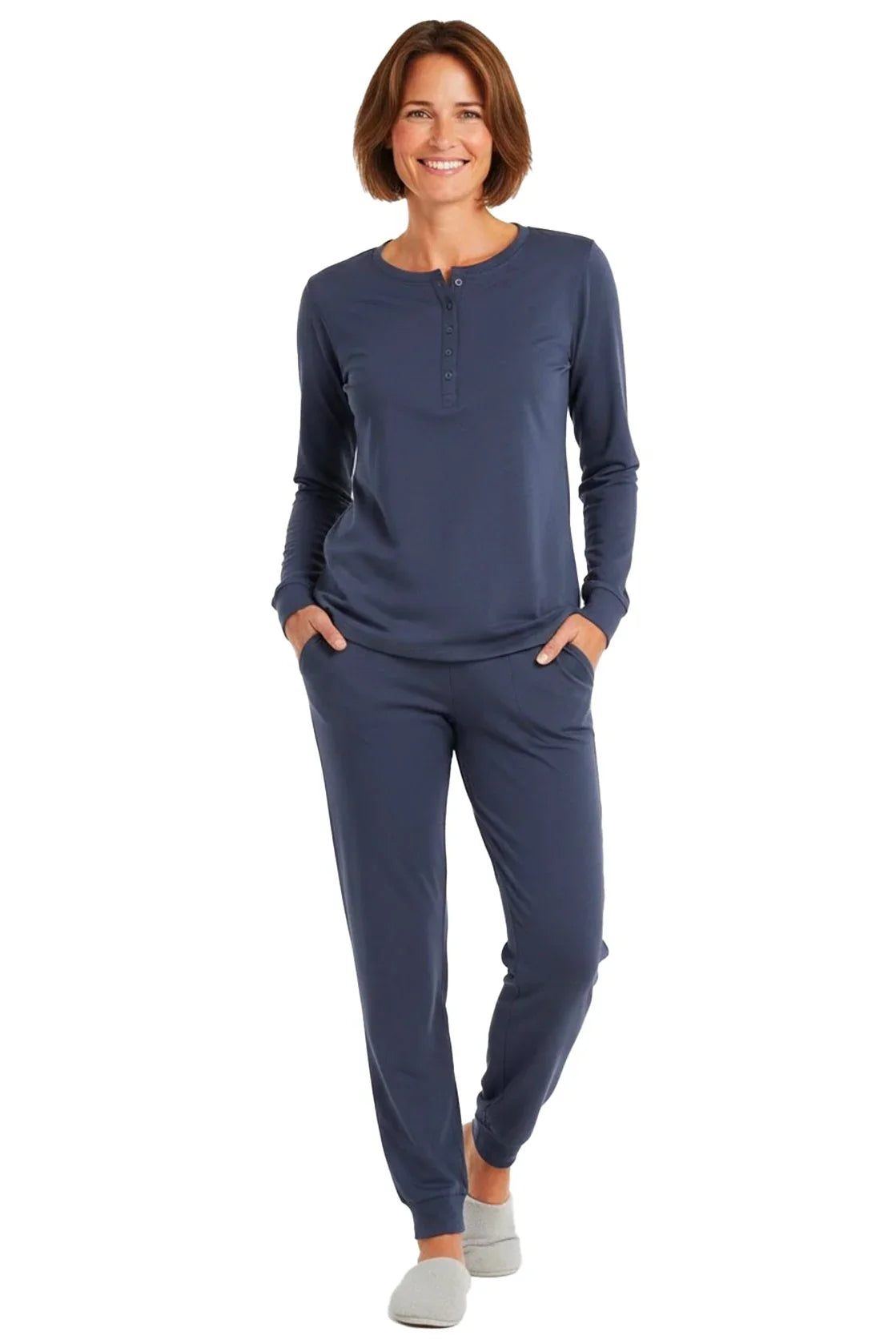 Smiling woman wearing steel blue long-sleeve henley top and matching jogger pants with gray slippers