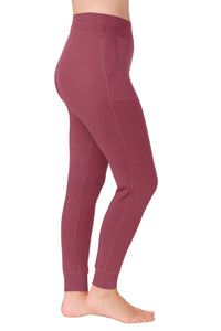 side view of woman wearing rosewood fitted leggings with side pockets and cuffed ankles